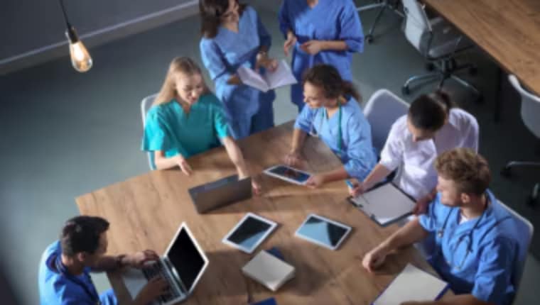 Healthcare professionals looking at disease education resources displayed on tablets